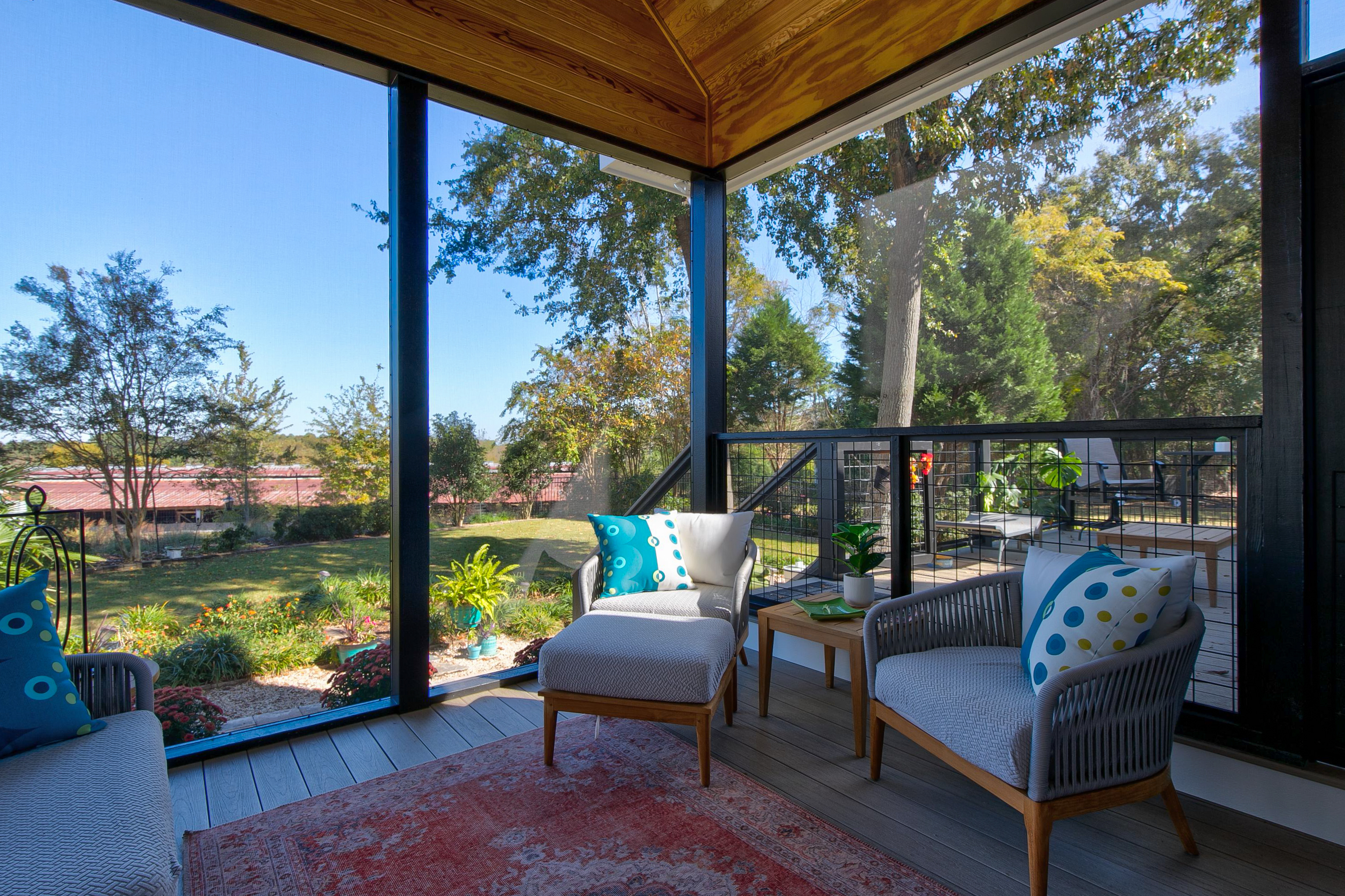 View of the inside of a screened back porch facing the chairs.