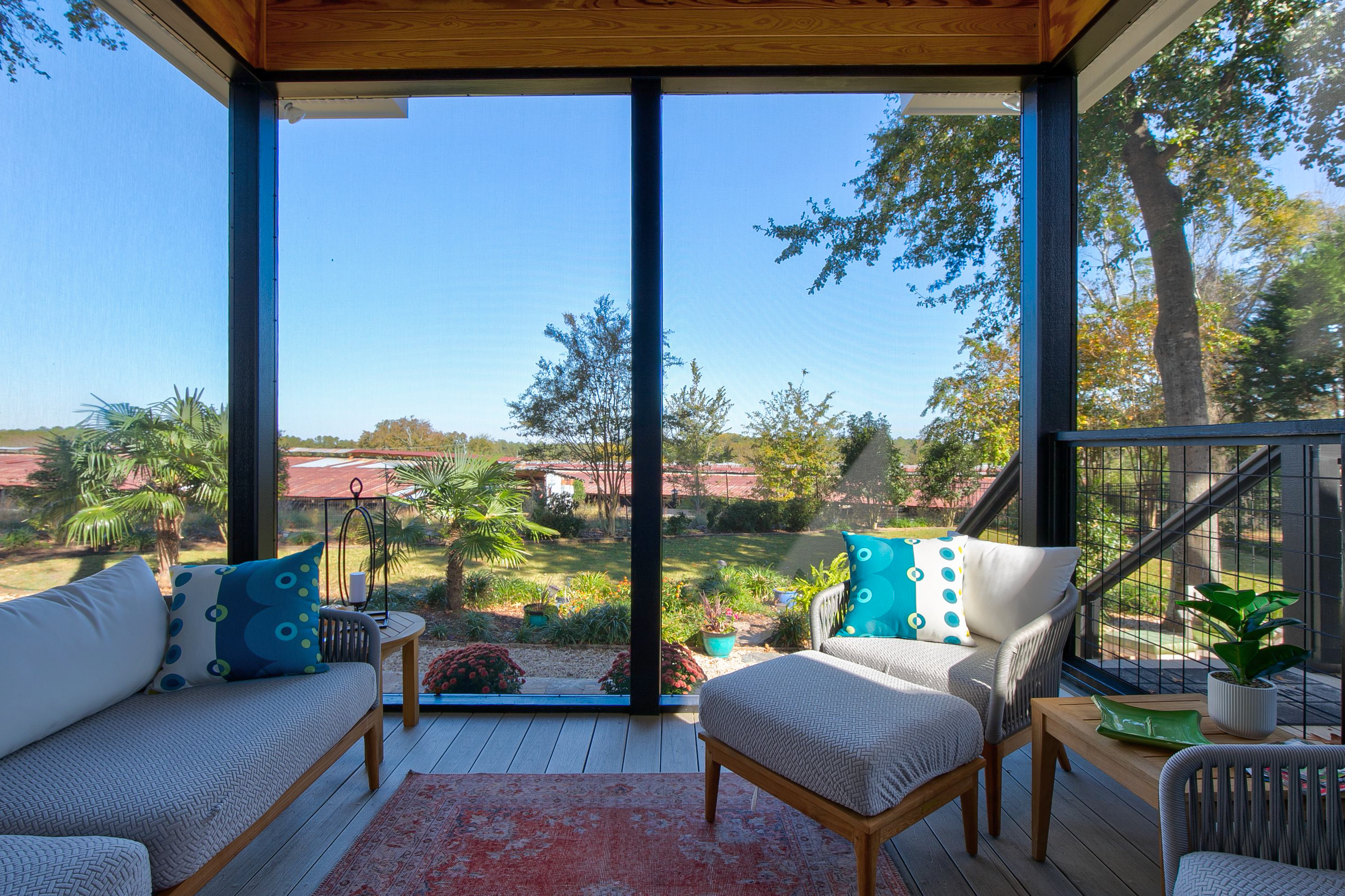 View of the inside of a screened back porch facing the backyard. 