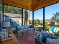 View of the inside of a screened back porch facing the couch.