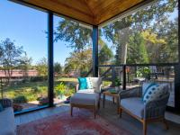 View of the inside of a screened back porch facing the chairs.