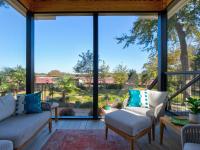 View of the inside of a screened back porch facing the backyard.