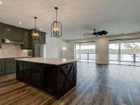 Custom Rafter B kitchen featuring stone countertops and stainless steel appliances in a lakeside home