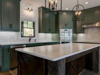 Custom Rafter B kitchen featuring stone countertops and stainless steel appliances in a lakeside home