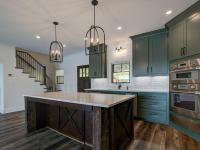 Custom Rafter B kitchen featuring stone countertops and stainless steel appliances in a lakeside home