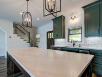 Custom Rafter B kitchen featuring stone countertops and stainless steel appliances in a lakeside home