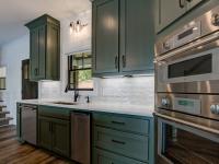 Custom Rafter B kitchen featuring stone countertops and stainless steel appliances in a lakeside home