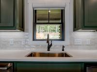 Custom Rafter B kitchen featuring stone countertops and stainless steel appliances in a lakeside home