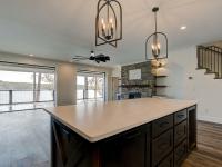 Custom Rafter B kitchen featuring stone countertops and stainless steel appliances in a lakeside home