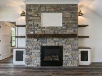 Custom Rafter B living room featuring stone fireplace 