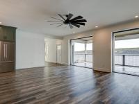 Custom Rafter B living room featuring large open sliding glass doors in a lakeside home