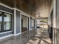Screened porch on rear of custom home featuring wooden floors and ceiling and large sliding glass doors