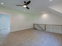 Carpeted interior room with railing