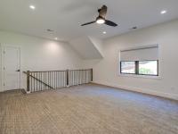 Carpeted interior room with railing