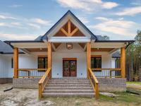 Front porch of white craftsman style home with wood accents