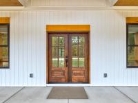 Wooden front door of white craftsman style home