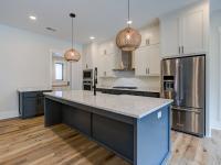 Open concept kitchen with white cabinets and large island - Rafter B Construction custom home