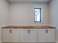 Butler's Pantry off of the main kitchen with white cabinets and prep space