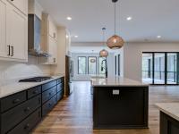 Open concept kitchen with white cabinets and large island - Rafter B Construction custom home