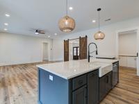 Open concept kitchen with white cabinets and large island - Rafter B Construction custom home