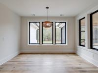 Dining room with wood floors, white walls and large windows