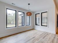 Dining room with wood floors, white walls and large windows