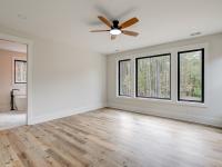 Room with wood floors, white walls and large windows and ceiling fan