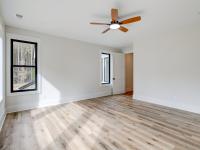 Room with wood floors, white walls and large windows and ceiling fan