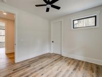 Room with wood floors, white walls and large windows and ceiling fan