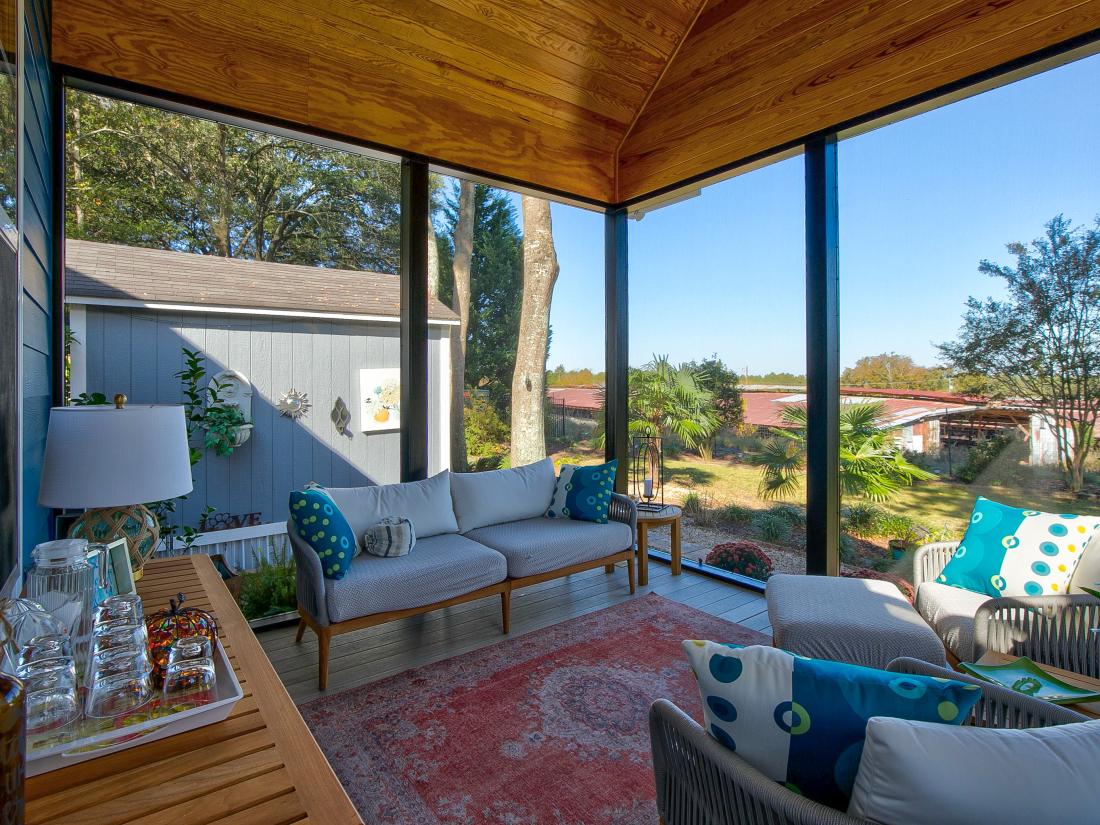 View of the inside of a screened back porch facing the couch.