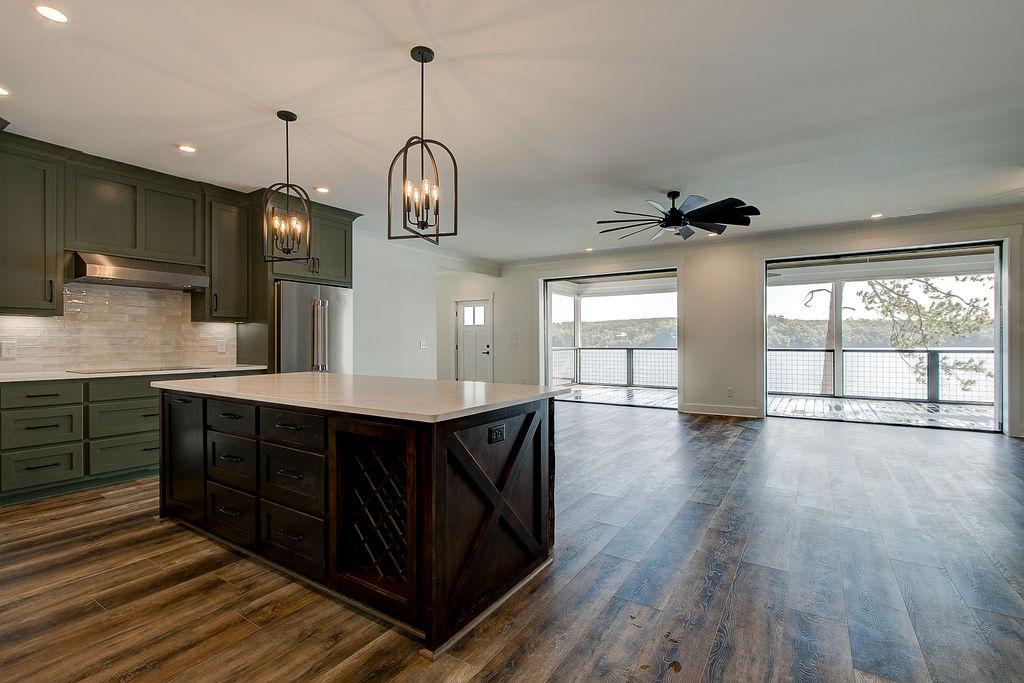Custom Rafter B kitchen featuring stone countertops and stainless steel appliances in a lakeside home