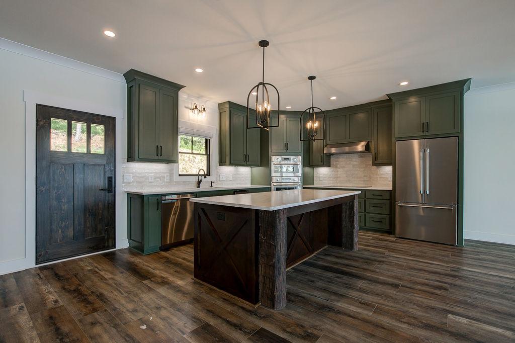 Custom Rafter B kitchen featuring stone countertops and stainless steel appliances in a lakeside home