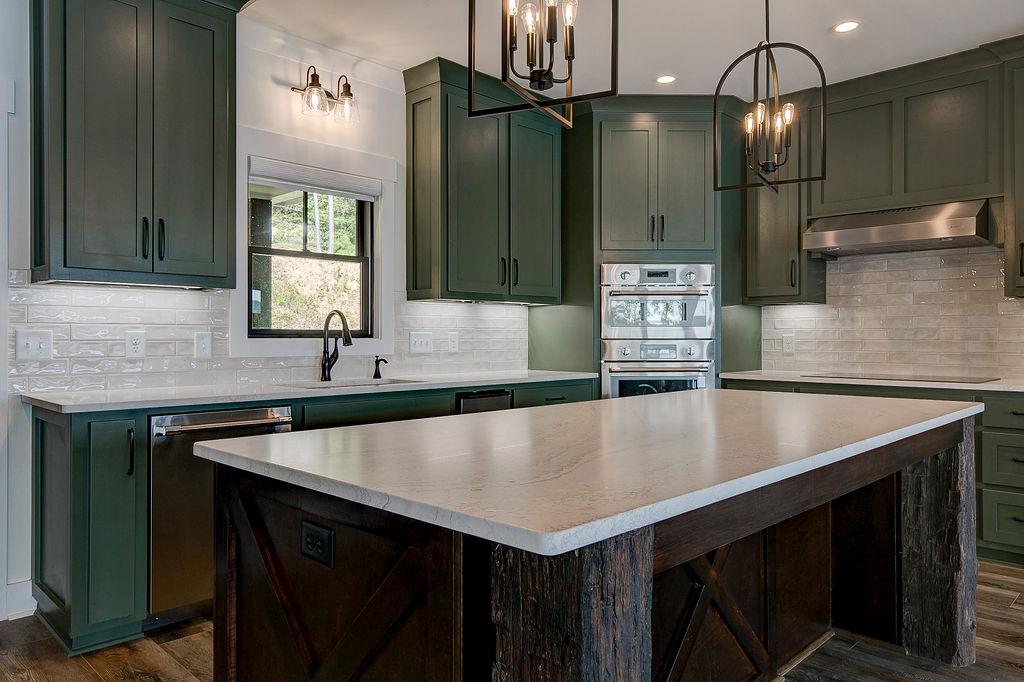 Custom Rafter B kitchen featuring stone countertops and stainless steel appliances in a lakeside home
