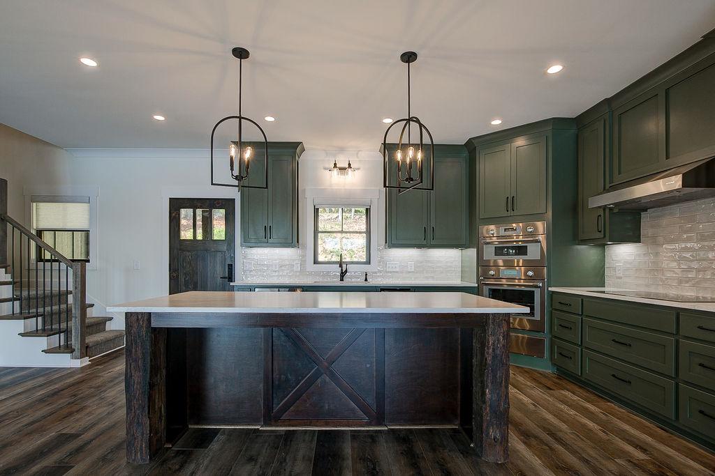 Custom Rafter B kitchen featuring stone countertops and stainless steel appliances in a lakeside home