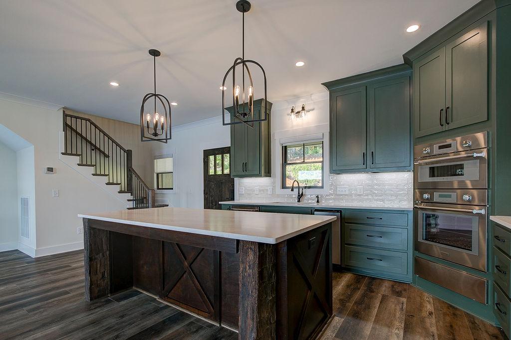 Custom Rafter B kitchen featuring stone countertops and stainless steel appliances in a lakeside home