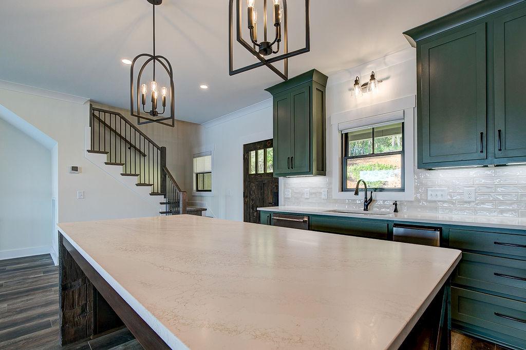 Custom Rafter B kitchen featuring stone countertops and stainless steel appliances in a lakeside home