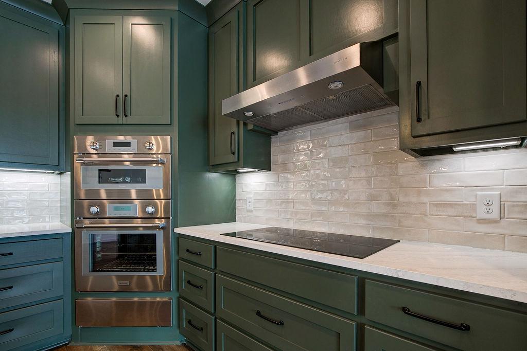 Custom Rafter B kitchen featuring stone countertops and stainless steel appliances in a lakeside home