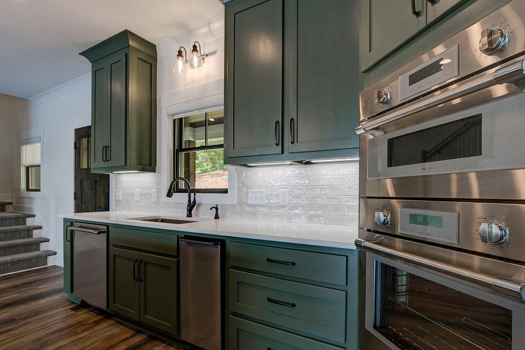 Custom Rafter B kitchen featuring stone countertops and stainless steel appliances in a lakeside home