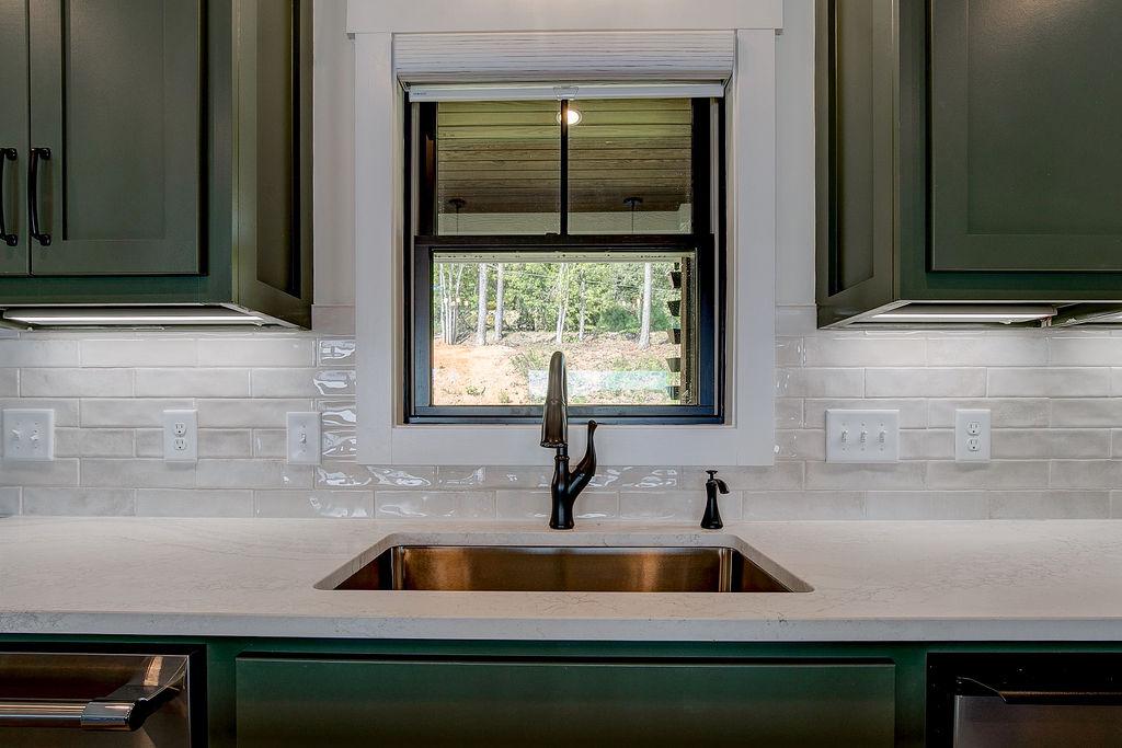 Custom Rafter B kitchen featuring stone countertops and stainless steel appliances in a lakeside home