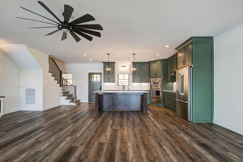 Custom Rafter B kitchen featuring stone countertops and stainless steel appliances in a lakeside home