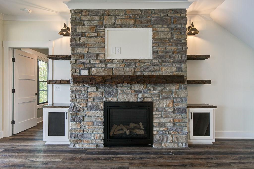 Custom Rafter B living room featuring stone fireplace 