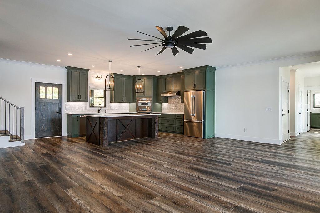 Custom Rafter B kitchen featuring stone countertops and stainless steel appliances in a lakeside home