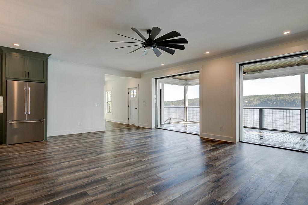 Custom Rafter B living room featuring large open sliding glass doors in a lakeside home