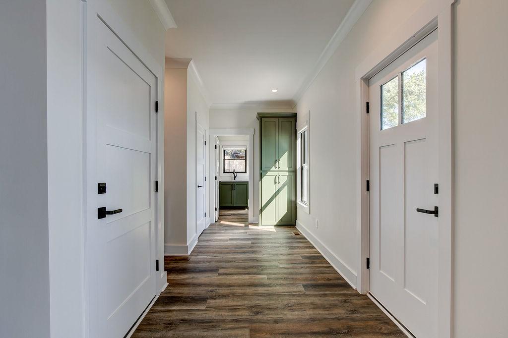 Interior hallway with built-in cabinetry and wooden floors