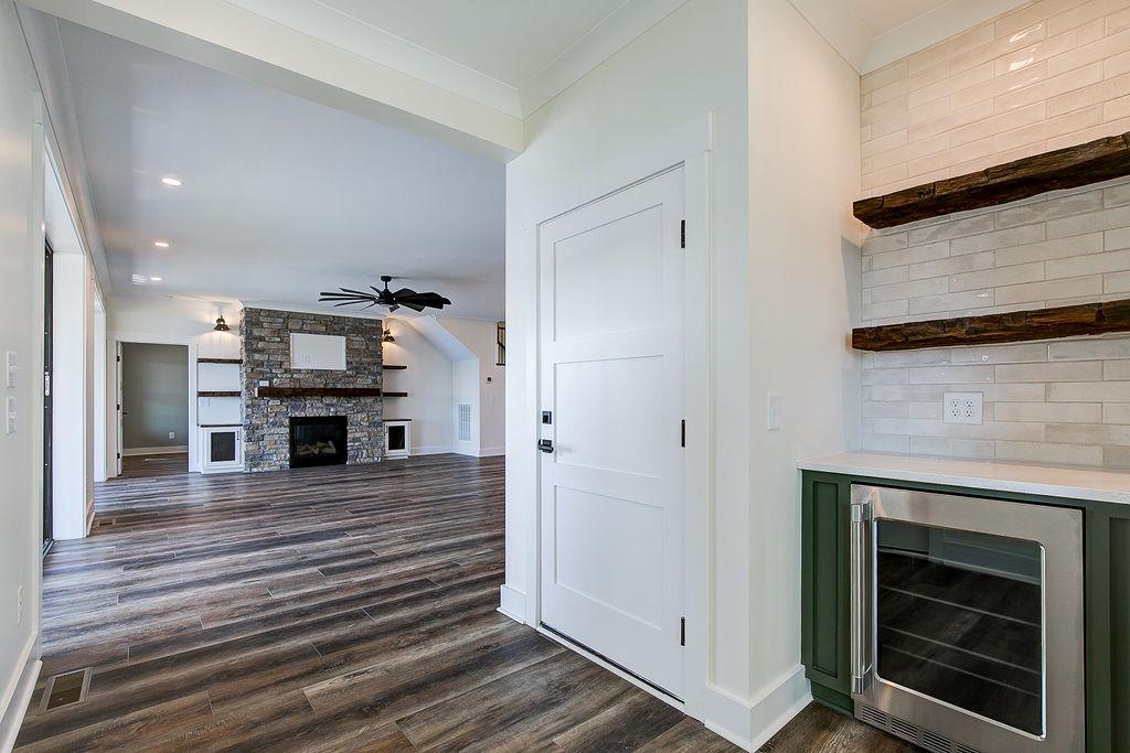 Interior hallway with built-in cabinetry and wooden floors and beverage cooler