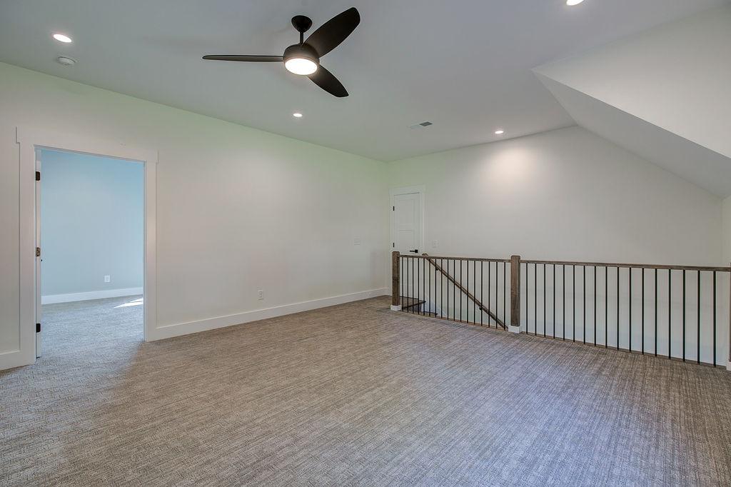 Carpeted interior room with railing