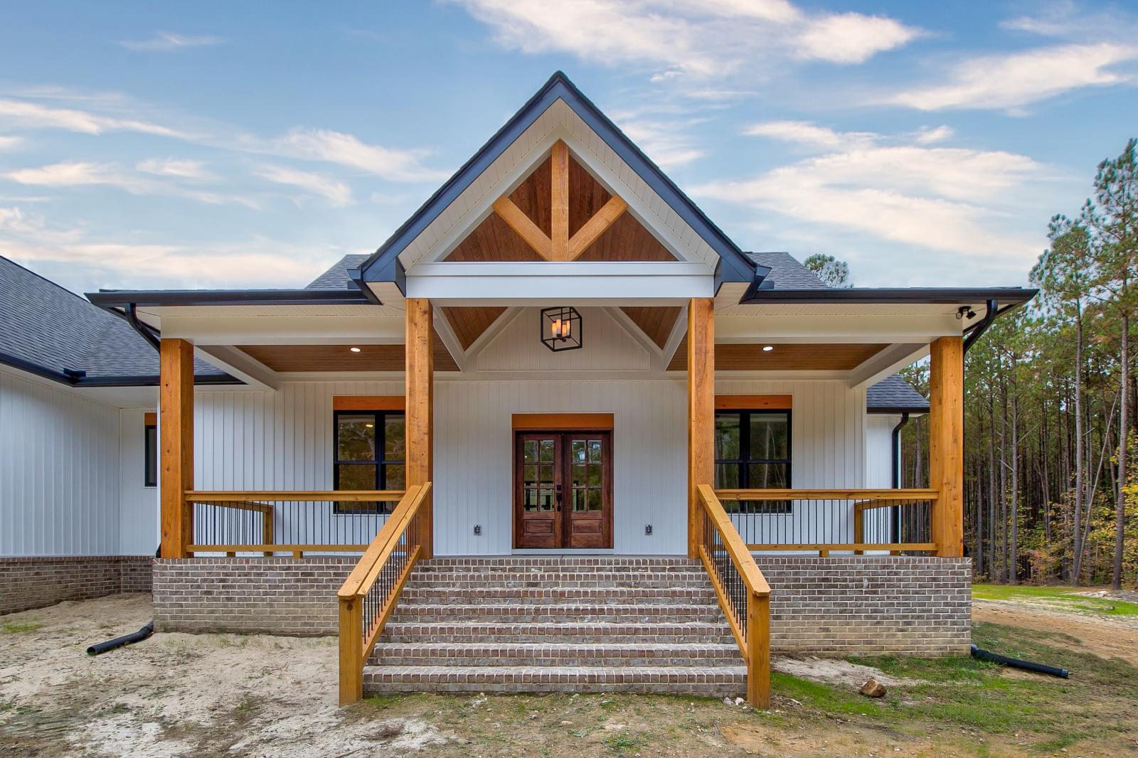 Front porch of white craftsman style home with wood accents