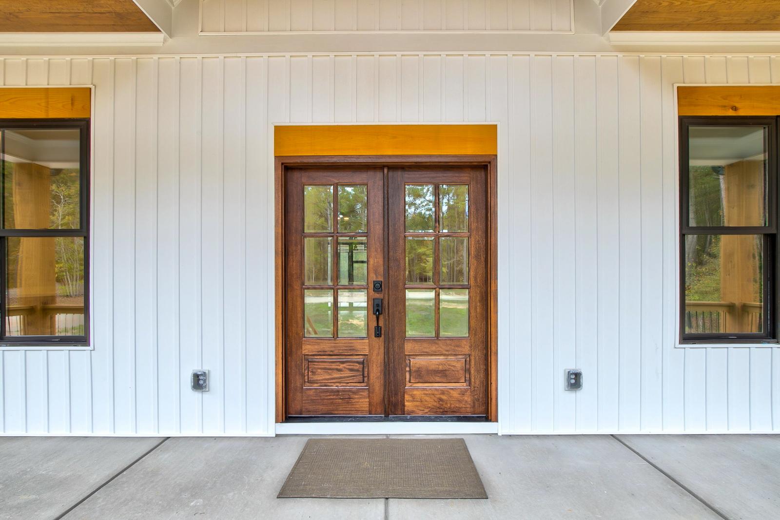 Wooden front door of white craftsman style home