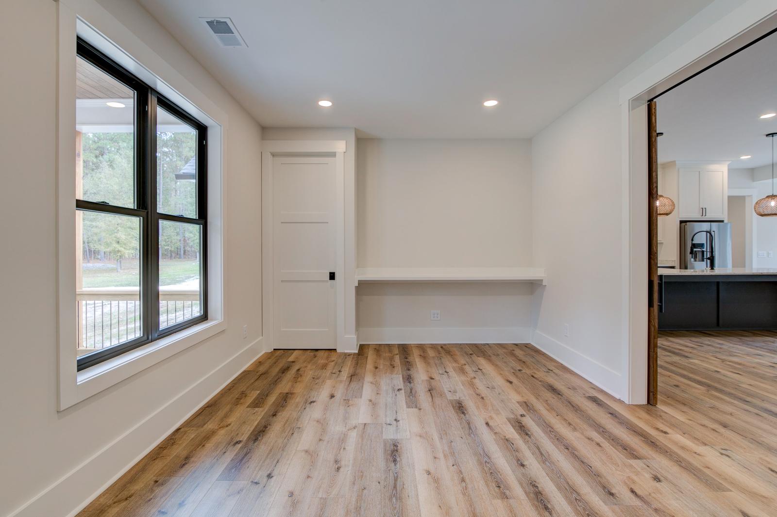 Room with white walls and wooden floors - Rafter B Construction custom home