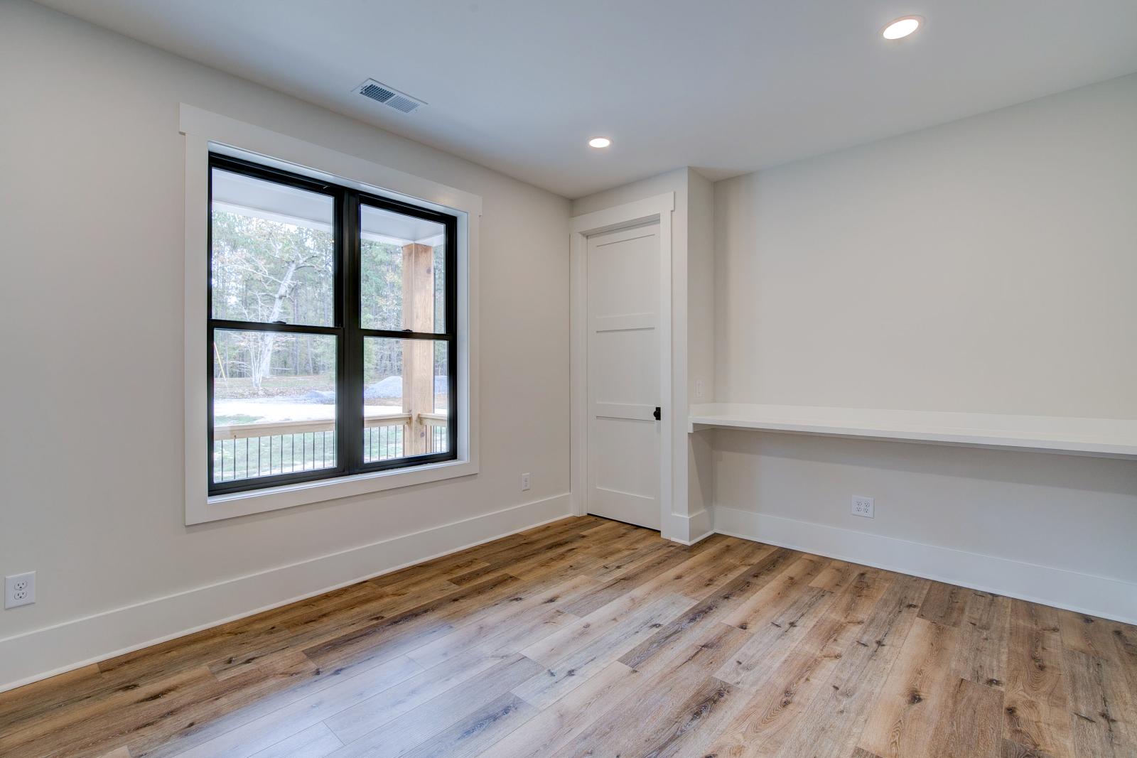 Room with white walls and wooden floors - Rafter B Construction custom home