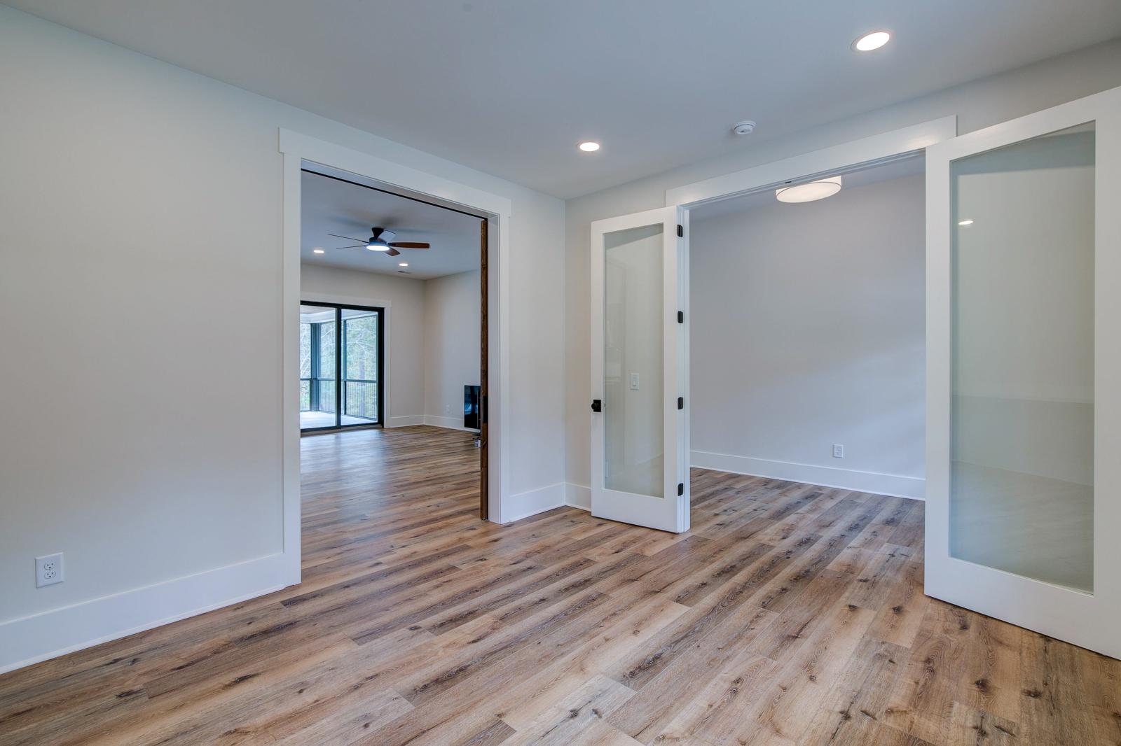 Room with white walls and wooden floors - Rafter B Construction custom home